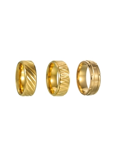 Detailansicht von drei goldfarbenen Metallringen mit texturierten und geometrischen Designs