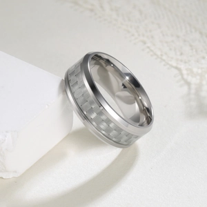 Detail of 8mm black titanium steel ring with blue carbon fiber inlay on white stone
