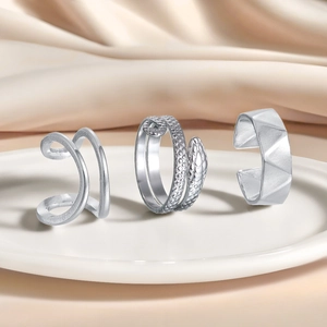 Silbernes 3er-Ring-Set mit Schlangenmuster und geometrischen breiten Ringen auf Seide