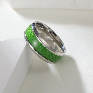 Detail view of silver titanium steel ring with green carbon fiber inlay texture