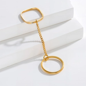 Minimalist gold plated stainless steel square ring with chain tassel on white pedestal