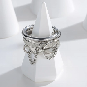 Polished silver stainless steel stacked ring set with hanging chain details on white cone