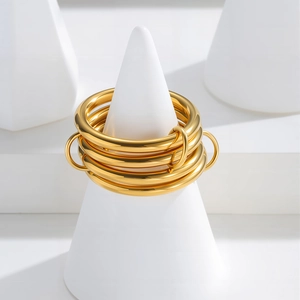 Polished 18K gold plated multi-layer stackable rings set on white geometric display