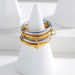 Polished four-layer stackable rings in gold and silver finish on jewelry stand