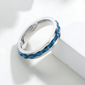 Macro detail of 6mm silver stainless steel ring with blue spinning gear wave design