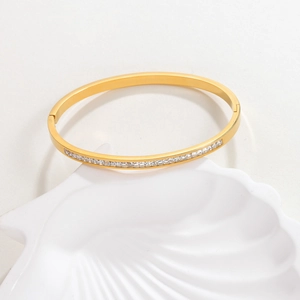 Bracelet jonc en acier doré serti de cristaux carrés sur un plateau en coquillage