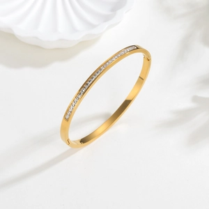 Bracelet élégant en acier titane doré orné d'une rangée de zircons carrés sur fond blanc