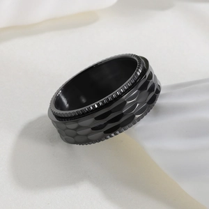 Close-up of 8mm black spinner ring featuring punk style hammered texture and knurled edges