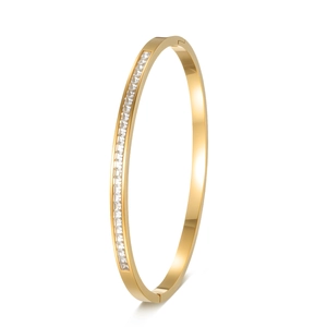 Détail du bracelet en acier doré avec zircons de coupe carrée sur fond blanc