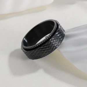 Detailed macro view of 8mm black rotating stress relief ring with cross-hatch texture