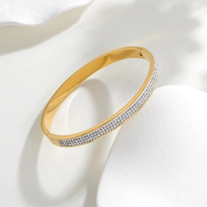 Gold titanium steel bracelet featuring a half-circle of micro-paved cubic zirconia stones
