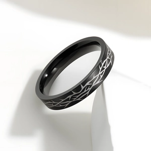 Macro shot of 4mm black stainless steel ring with silver thorn pattern and dark gothic style