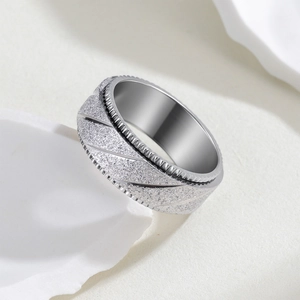 Détail macro de la bague en acier argenté de 8 mm avec finition mate et rainures diagonales