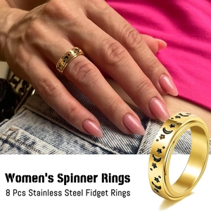 Detailed view of 8-piece gold stainless steel spinner rings with moon and star patterns