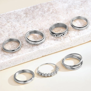 Detailed close-up of 7-piece silver stainless steel spinner ring set with star patterns