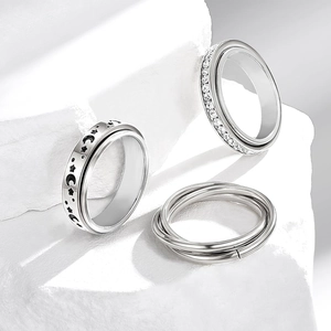 Detailed view of silver stainless steel spinner rings with moon star motifs and zircons