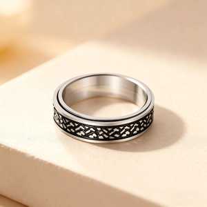 Mens stainless steel spinning ring with Celtic knot pattern on a stone pedestal