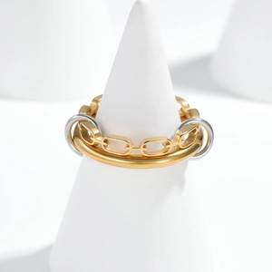 Multi-layer chain ring with mixed gold and silver tones on a white display stand