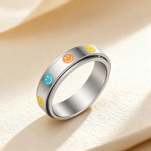 Polished 304 stainless steel spinner ring with colorful smiley face patterns on beige paper