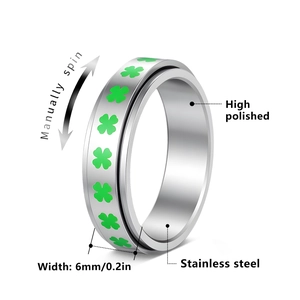 Polished stainless steel spinner ring with green four-leaf clover pattern for stress relief