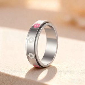 Spinning fidget ring with pink and white daisy flowers on polished stainless steel band