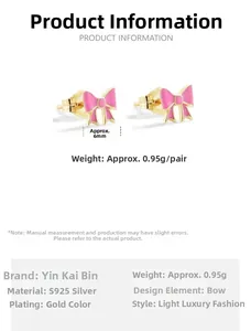 Macro shot of 925 sterling silver bow earrings with pink enamel and gold plating