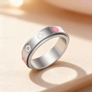 Rotating stainless steel anxiety ring with pink and white flower charms on silver band