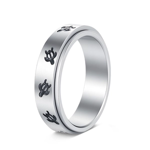 Macro view of stainless steel spinner ring featuring black turtle patterns and brushed finish