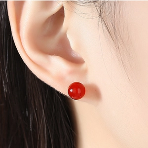 Close-up of elegant S925 silver stud earrings with vibrant red carnelian agate beads