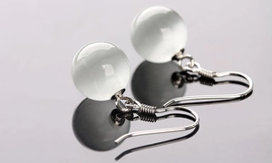 Macro detail of silver cat eye stone earrings with delicate wire wrapping hook