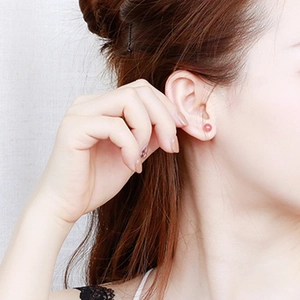 Close-up of S925 sterling silver strawberry quartz stud earring worn on ear lobe