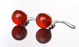 Détail macro de perles d'agate rouge sur crochets en argent au fini poli