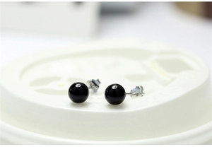 Macro shot of 925 sterling silver studs with polished black onyx bead and butterfly backs