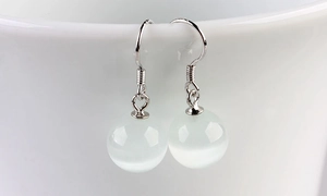 Close-up of elegant S925 silver earrings with translucent cat-eye stone beads