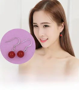 Gros plan de boucles d'oreilles en argent 925 avec perles d'agate rouge sur un mannequin