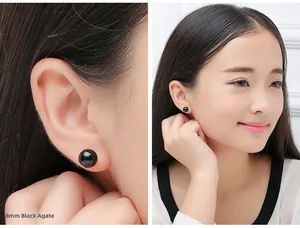 Detailed view of 8mm black agate stud earrings on ear with model presentation