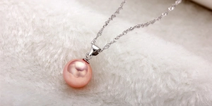 Macro shot of large pink round pearl pendant with S925 sterling silver twist rope chain
