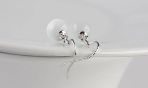 Detail of minimalist S925 silver earrings featuring translucent white cat eye stone beads