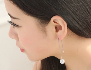Close-up of S925 silver ear threader with sparkling round zircon on a female model