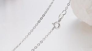Macro shot of S925 sterling silver lobster clasp with Italy hallmark and cross chain link