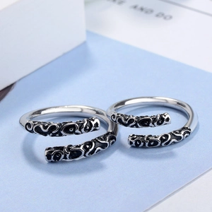 Macro detail of retro Thai silver rings featuring intricate embossed cloud patterns