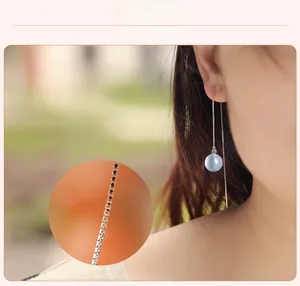 Gros plan d'une boucle d'oreille en argent avec pendentif en œil-de-chat bleu sur mannequin