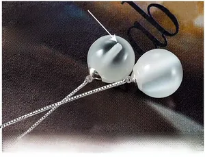 Détail macro de boucles d'oreilles œil-de-chat naturel avec incrustation de fil d'argent