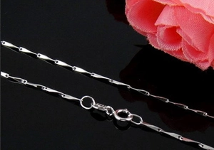 Macro shot of S925 sterling silver chain with spring clasp and polished hallmark detail