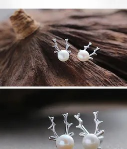 Detailed view of silver reindeer antler earrings with elegant white pearls on lotus pod