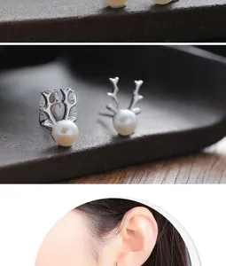 Detailed view of silver deer antler earrings with white pearls and model wearing preview