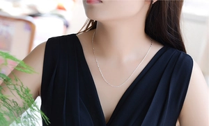 Primo piano della collana a catena minimalista in argento S925 da 1mm sul collo di modella