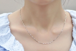 Close-up of S925 sterling silver water wave chain necklace worn on neck detail