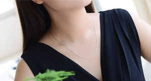 Dettaglio di una delicata catena in argento 925 da 1mm sulla clavicola di una modella