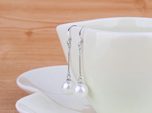 Detail of 925 sterling silver drop earrings with elegant 10mm round white natural pearls